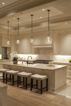 a kitchen with an island and stools in the center, surrounded by white cabinets