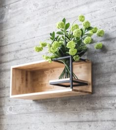 a wooden shelf with flowers in it on the wall