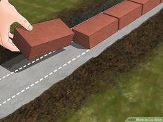 a hand is placing bricks on the side of a road to make it easier for people to move around