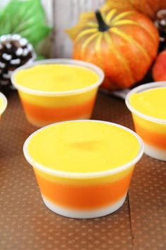 candy corn jello shots recipe on a table with apples and pumpkins in the background