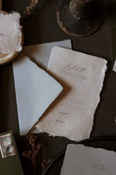 several pieces of paper on top of a table next to an envelope and other items