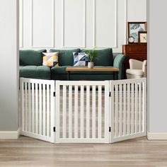 a living room with a green couch and white fenced in area next to a coffee table