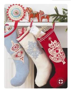 three christmas stockings hanging from a mantel