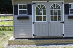 a shed with two doors and windows on the side