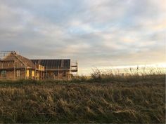 an old house in the middle of a field with scaffolding on it's roof