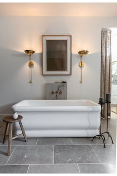 a white bath tub sitting on top of a tiled floor