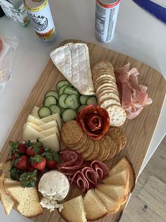 an assortment of cheeses, crackers and meats on a wooden platter