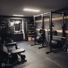 a home gym with black walls and gray carpeted flooring is pictured in this image