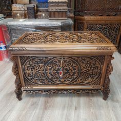 an ornate wooden box sitting on top of a floor next to other boxes in a store