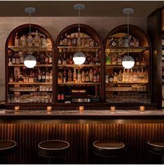 an image of a bar with stools and bottles on the back wall behind it