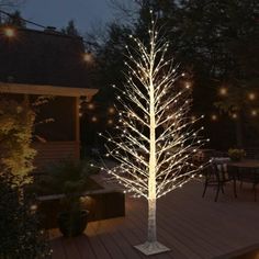 a lighted tree in the middle of a deck