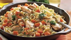 pasta with chicken and carrots in a skillet