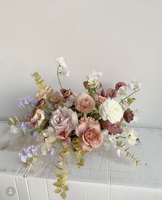 a bouquet of flowers sitting on top of a white box with no people around it