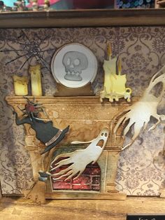 a fireplace decorated with halloween decorations and ghost figurines