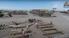 several people are standing around wooden planks on the ground