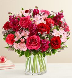 a vase filled with red and pink flowers