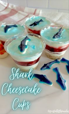 four small dessert cups with blue and red toppings on white table cloth next to each other