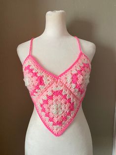 a pink and white crocheted top on a mannequin