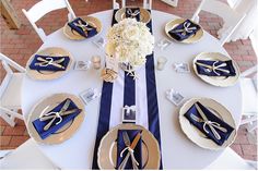 the table is set with blue and white napkins, silverware, and flowers