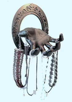 a hand that is hanging from the side of a circular wall hook with chains attached to it