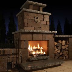 an outdoor fireplace lit up at night