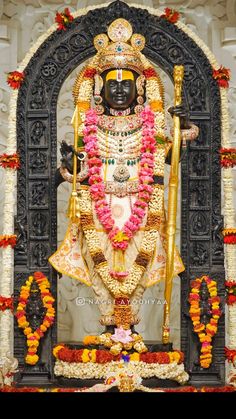 the statue is decorated with flowers and garlands