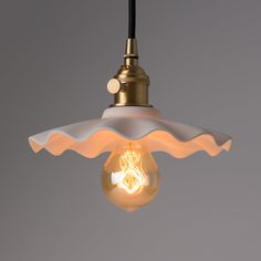 a light that is hanging from a ceiling with a lamp shade on top of it