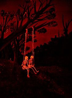 two people sitting on a swing in the dark with red light shining through them and trees behind them