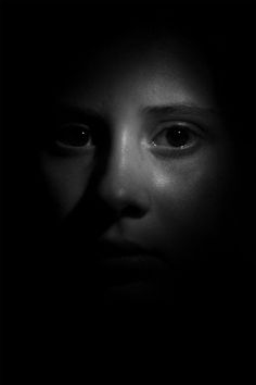 a woman's face is shown in the dark