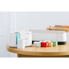 an assortment of items sitting on top of a wooden table in front of a white wall