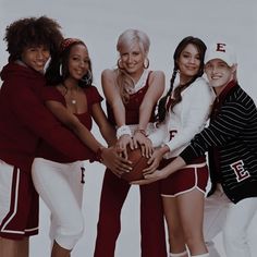 a group of women standing next to each other holding a basketball