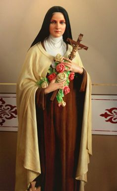 a statue of jesus holding flowers and a cross