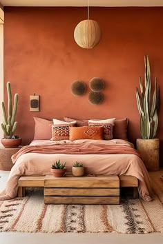 a bedroom with an orange wall and large cactus plants on the side of the bed