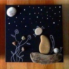 some rocks are sitting on top of a black and white board with stars in the sky