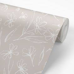 a pink wallpaper with white flowers and leaves on it's side, next to a roll of toilet paper