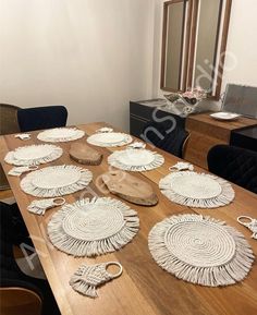 a wooden table topped with lots of white plates