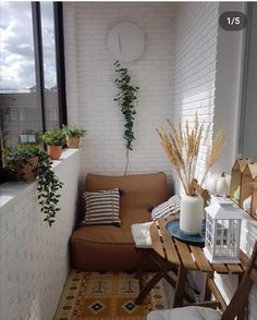 a living room with a couch, table and potted plants on the windowsill