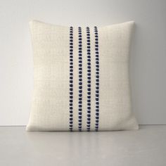 a white and blue pillow sitting on top of a table