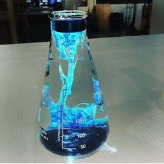 a blue liquid in a glass beakle on a table