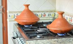 two clay pots sitting on top of a stove