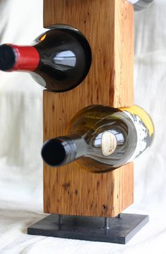 two bottles of wine are placed in a wooden holder