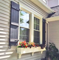 a window box filled with flowers on the side of a house