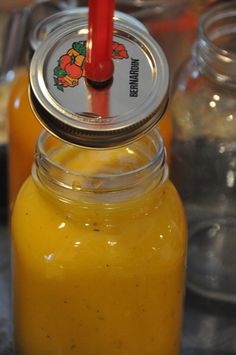 two jars filled with yellow liquid sitting on top of a table