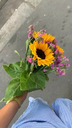 a person holding a bouquet of flowers in their hand