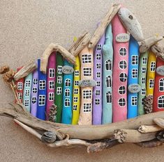 a colorful house made out of driftwood on the beach with words written on it