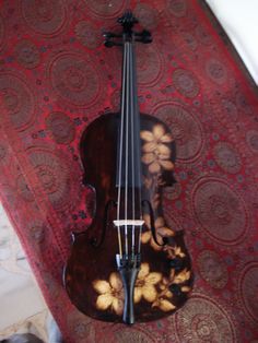 a violin laying on top of a red carpet