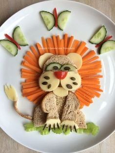 a lion made out of carrots and cucumbers on a plate