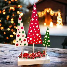 three small christmas trees sitting on top of a table