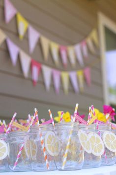 lemon slices and straws are lined up in mason jars with paper straws on them