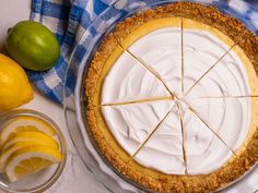 a pie with slices cut out and lemons next to it